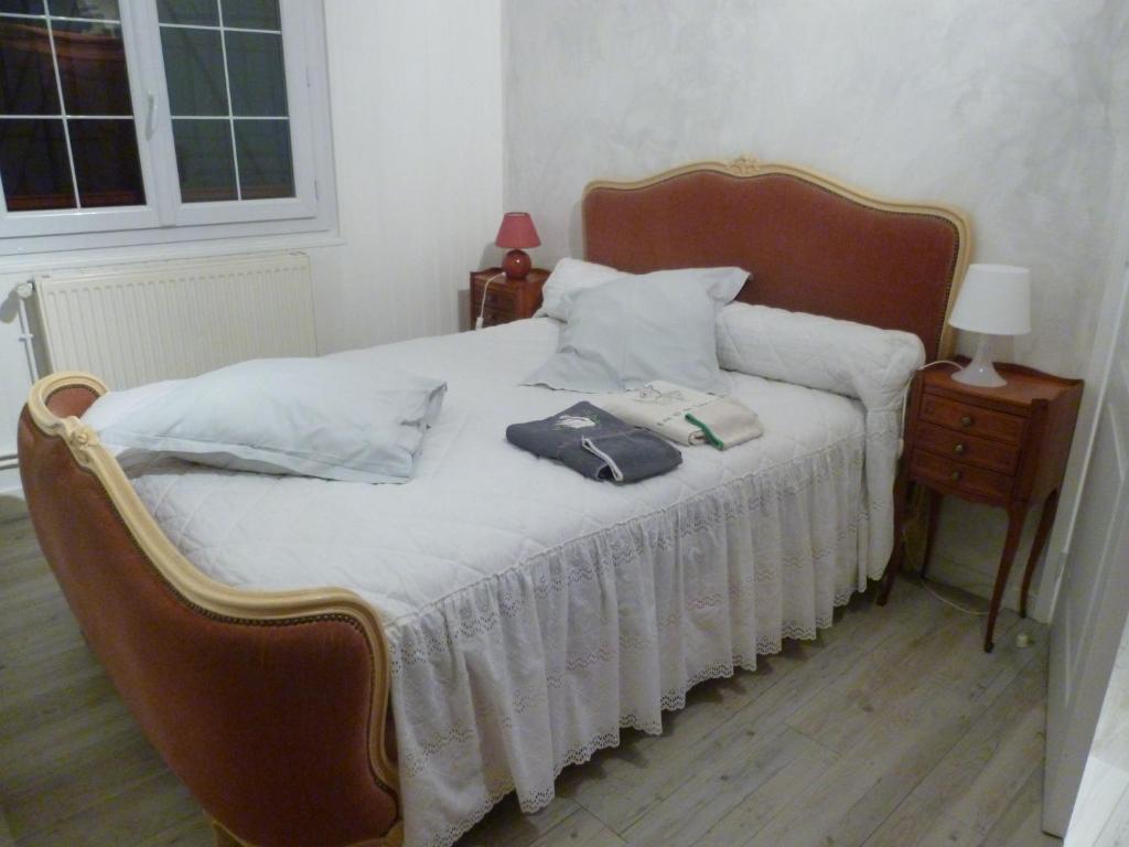 a bedroom with a bed with white sheets and pillows at Les ID de Saint Emilion in Saint-Émilion