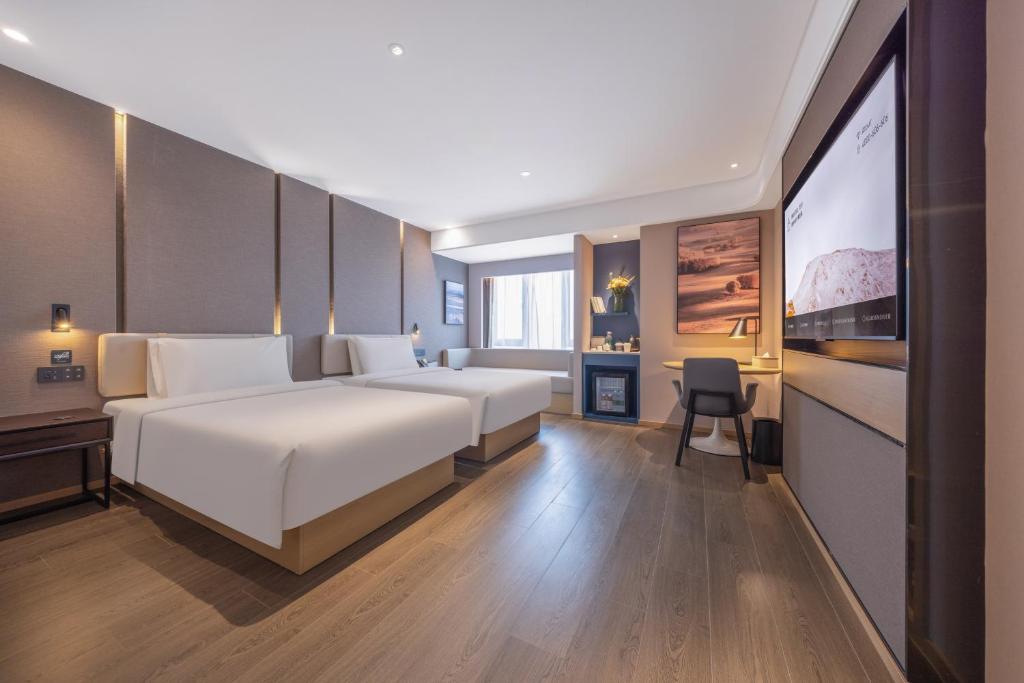 a bedroom with a large white bed and a desk at Atour Hotel Gukaifu Temple Furong Middle Road Changsha in Changsha