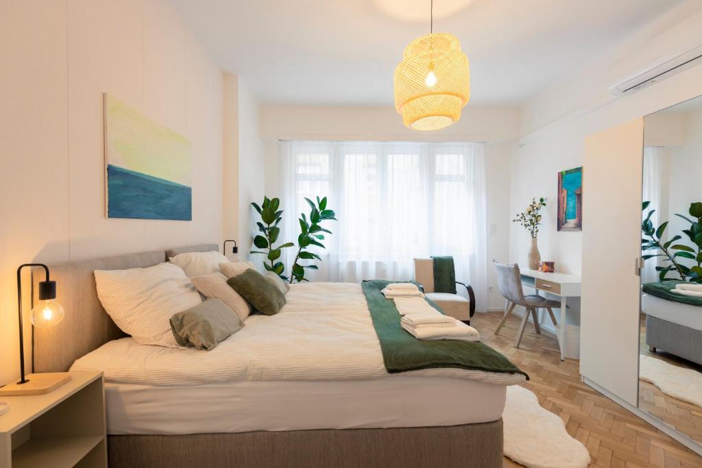 Hotel VentoBudapest with 1 optional PARKING, 4rooms & 4bathrooms, a bedroom with a large bed in a room with a desk at VentoBudapest with 1 optional PARKING, 4rooms & 4bathrooms in Budapest