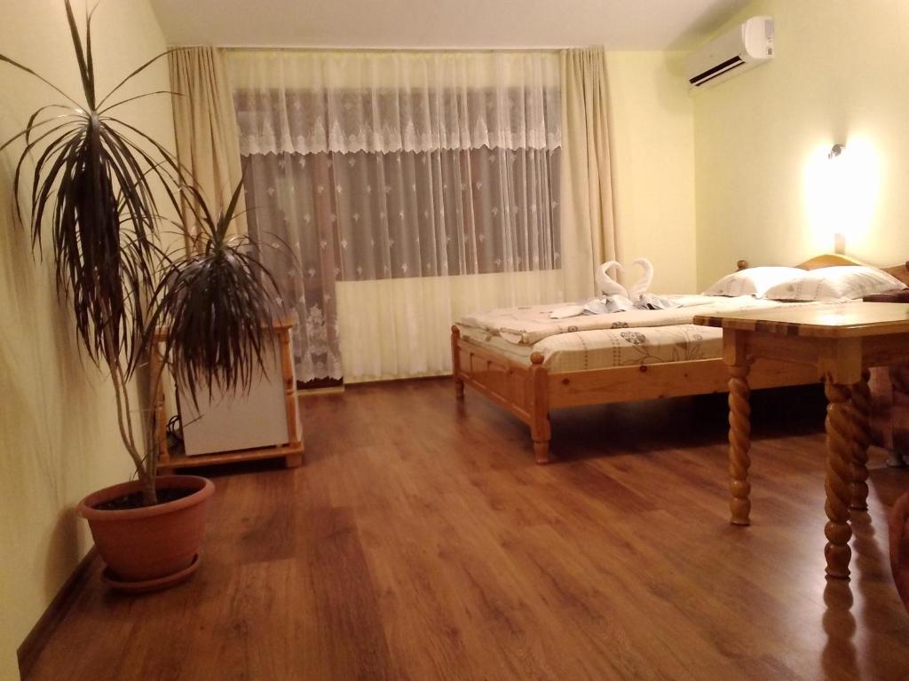 a bedroom with a bed and a potted plant at Guest House Diamant in Sozopol