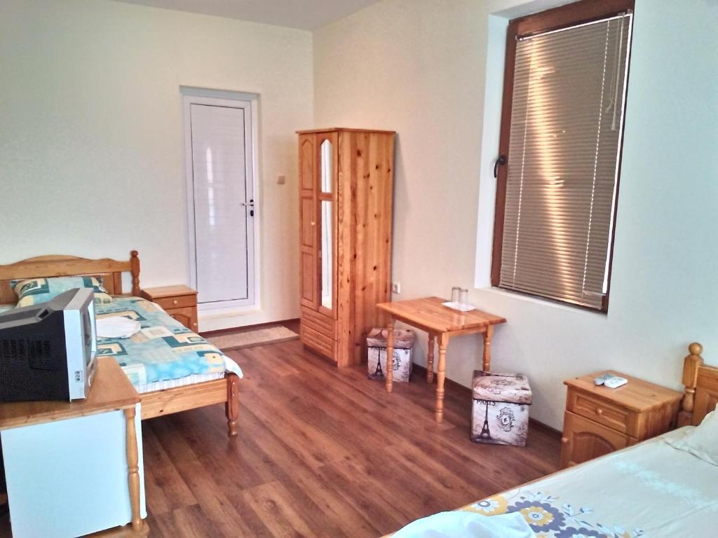 a bedroom with two beds and a table and a window at Guest House Diamant in Sozopol