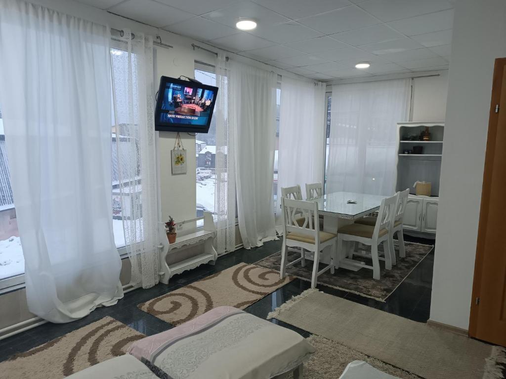 Una sala de estar con un televisor y una mesa y sillas. en Mountain Relax Vlašić, en Vlašić