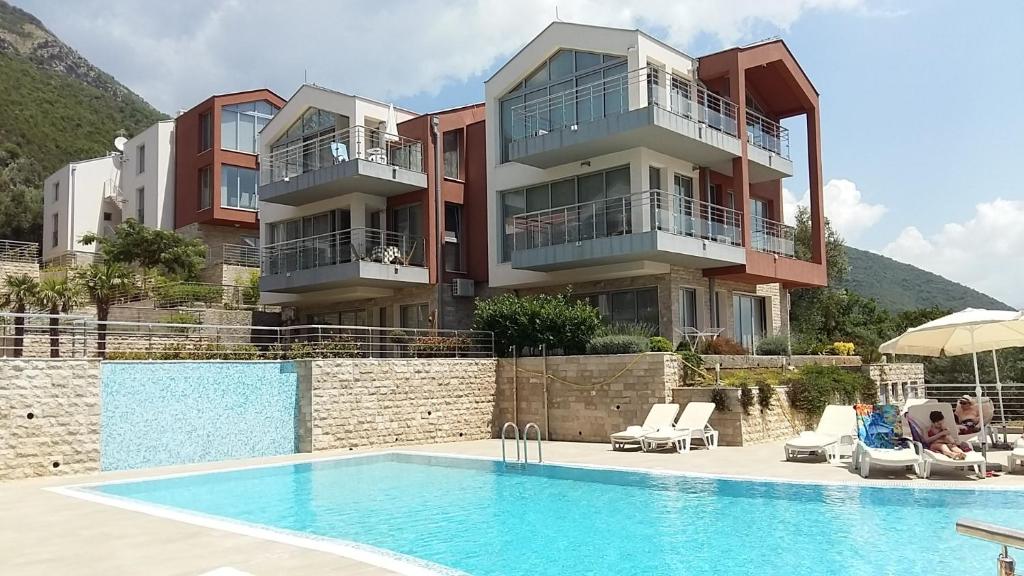 a building with a swimming pool next to a resort at Acacia Hill apartments B3 in Herceg-Novi