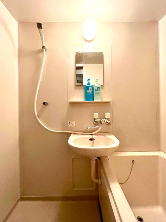 a bathroom with a sink and a mirror and a tub at Yadoya Hiraiwa private ryokan in Kyoto