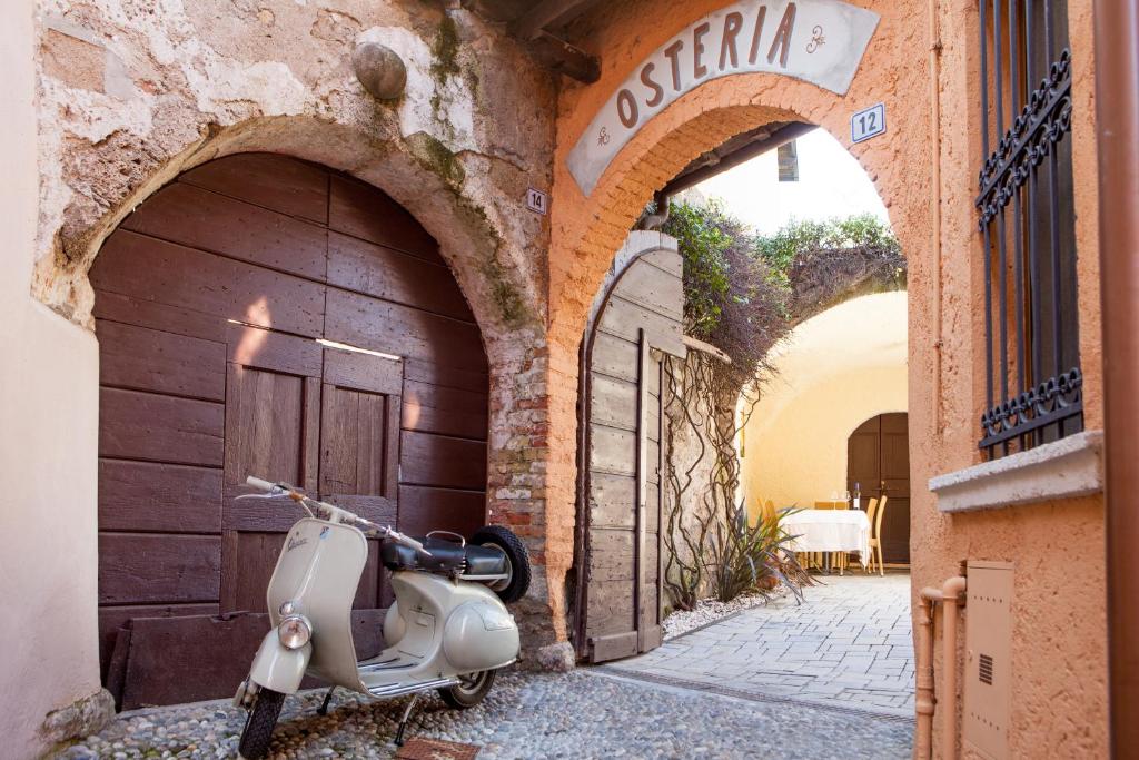 una moto estacionada en un callejón al lado de un edificio en B&B Antico Brolo, en Gardone Riviera