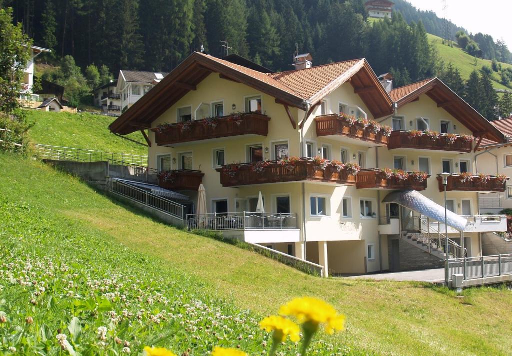 un gran edificio en una colina con un tobogán en Apparthotel Sonnwies en Selva dei Molini