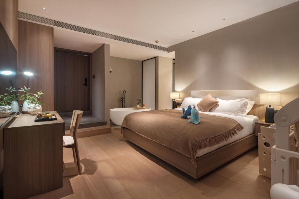 Postel nebo postele na pokoji v ubytování Qingdao Wushe Yujianshanju Tangchi Seaview Hotel