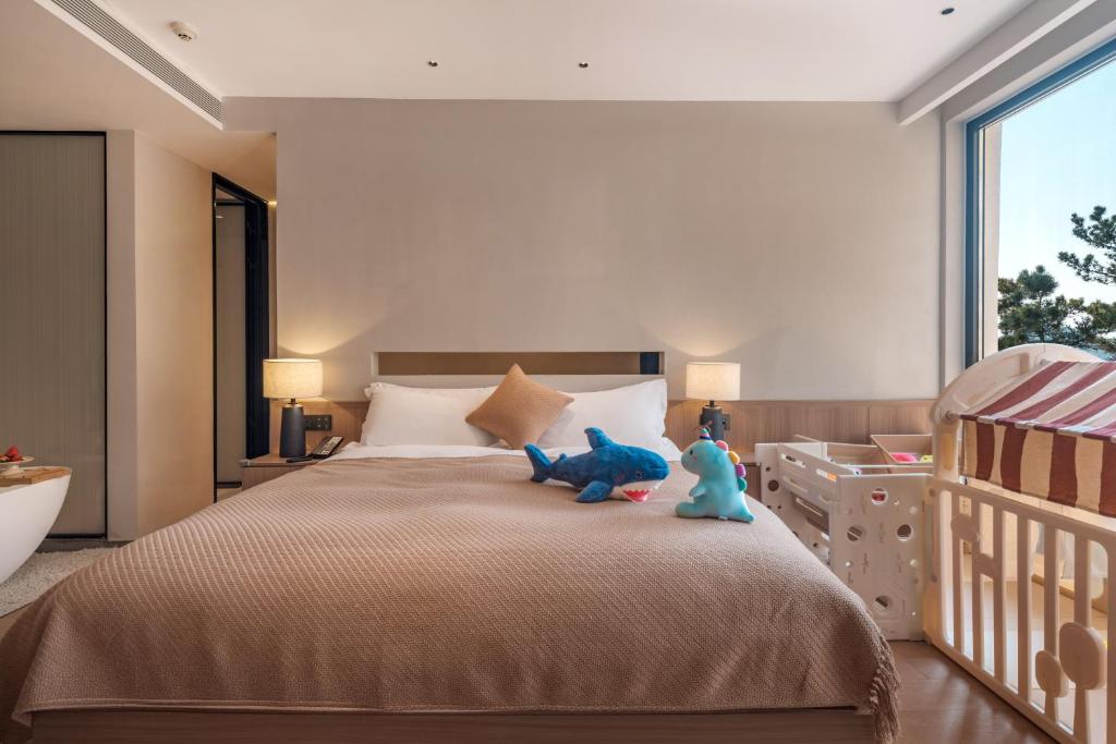 Postel nebo postele na pokoji v ubytování Qingdao Wushe Yujianshanju Tangchi Seaview Hotel
