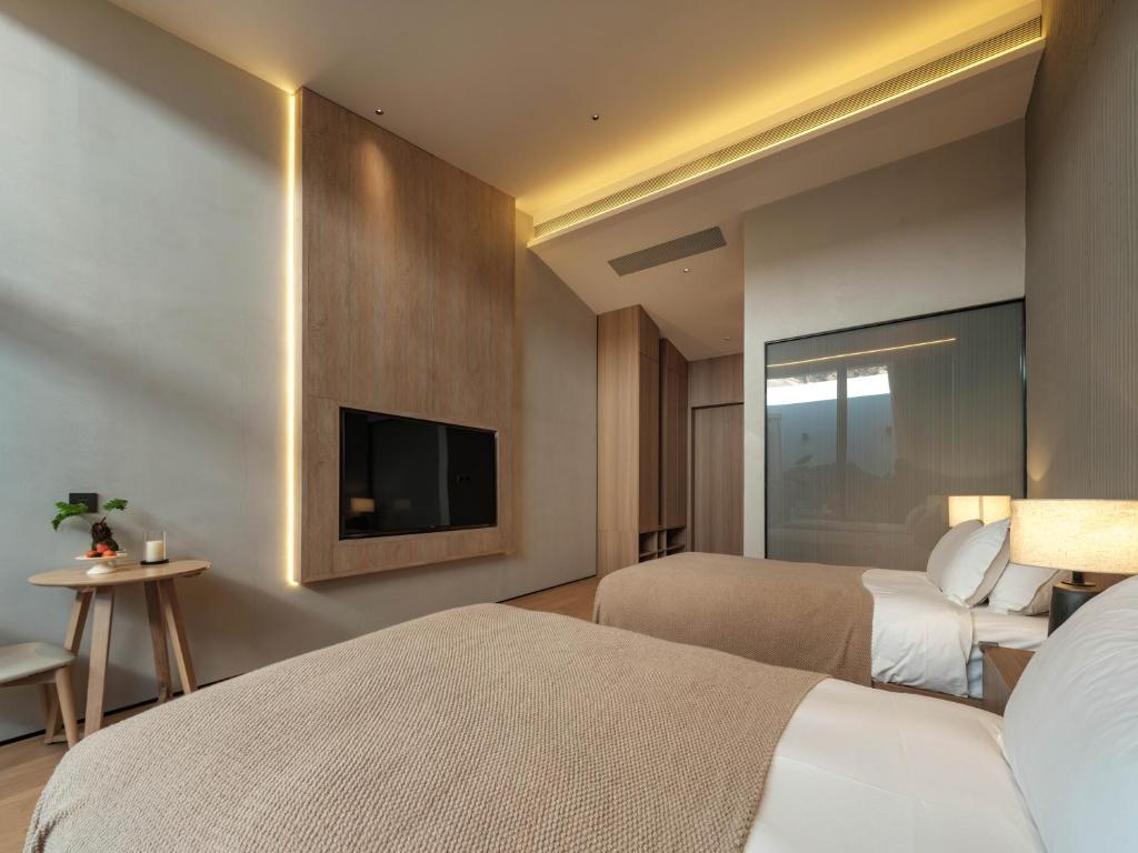 Postel nebo postele na pokoji v ubytování Qingdao Wushe Yujianshanju Tangchi Seaview Hotel