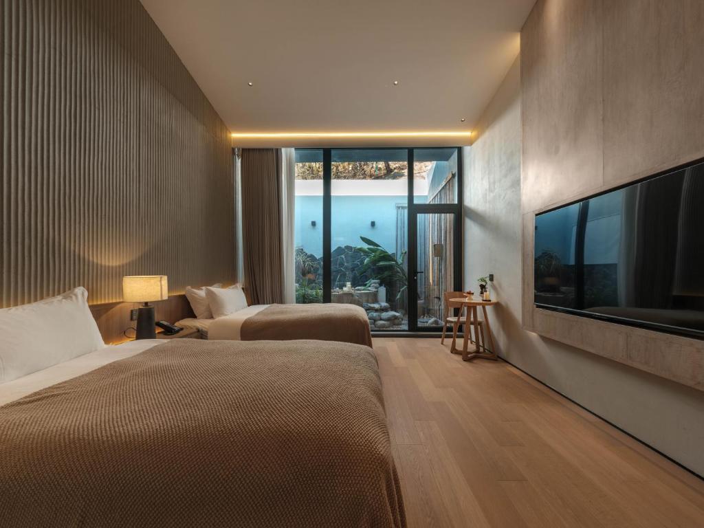Postel nebo postele na pokoji v ubytování Qingdao Wushe Yujianshanju Tangchi Seaview Hotel