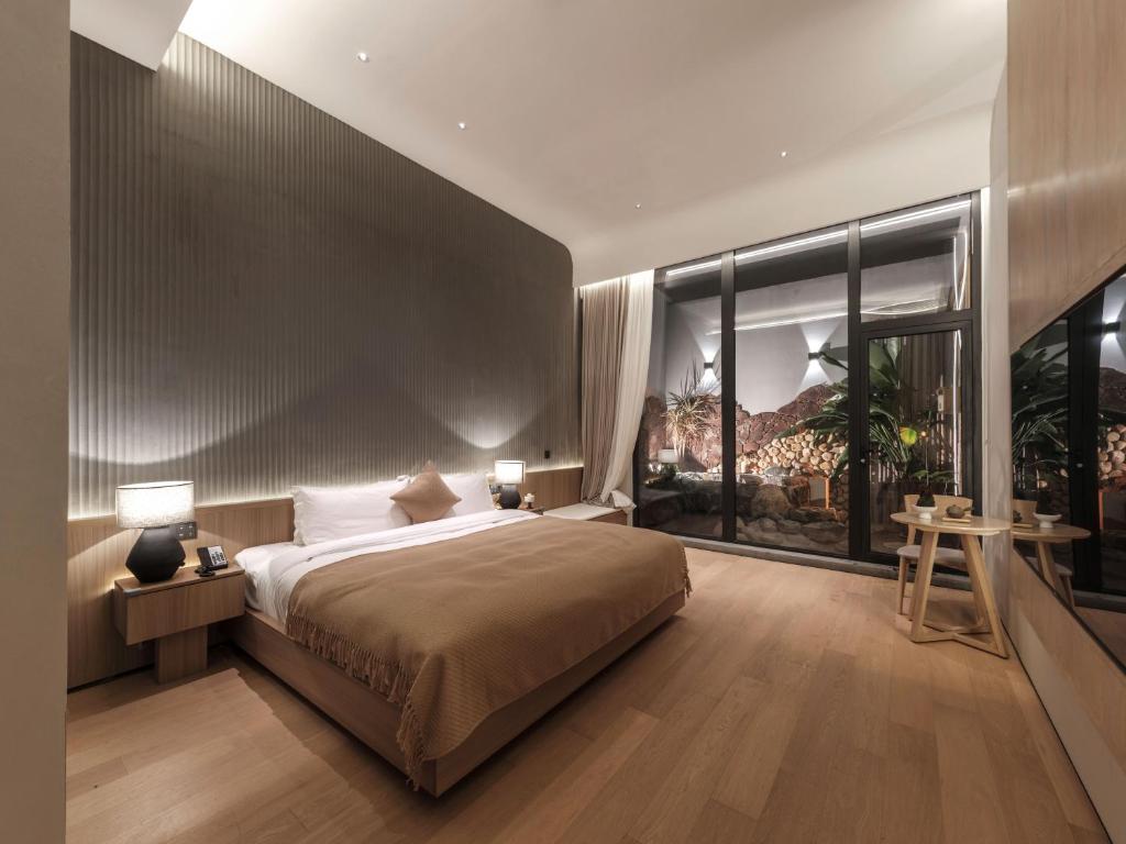 Postel nebo postele na pokoji v ubytování Qingdao Wushe Yujianshanju Tangchi Seaview Hotel
