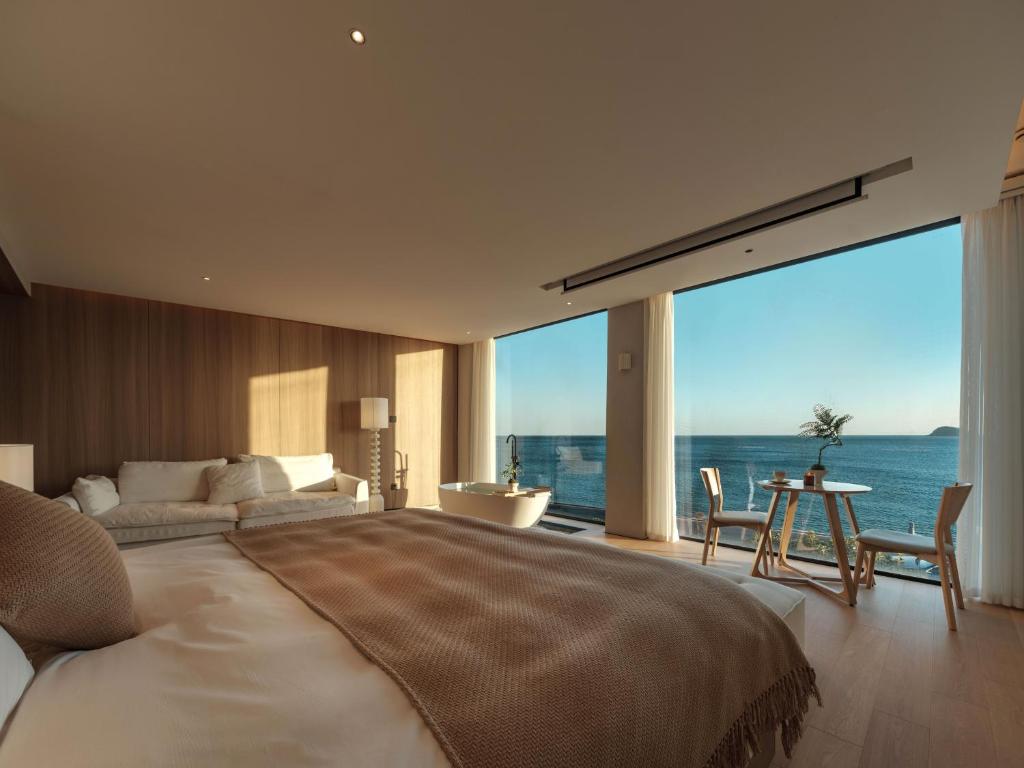 Postel nebo postele na pokoji v ubytování Qingdao Wushe Yujianshanju Tangchi Seaview Hotel