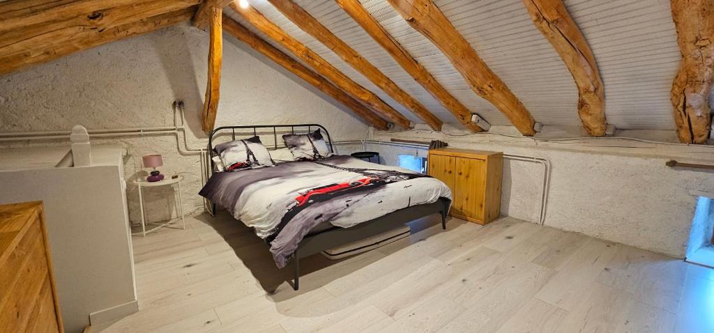 Un dormitorio con una cama en un ático en Legiteducerf, en Sengouagnet