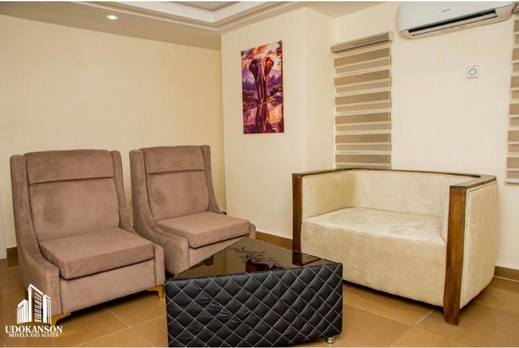 a living room with two chairs and a coffee table at Udokanson Hotel And Suites in Agbor