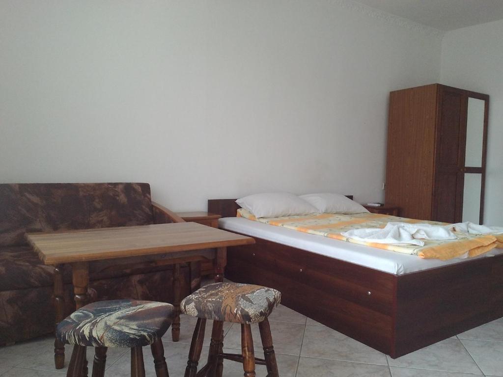 a bedroom with a bed and a table and two stools at Guest House Diamant in Sozopol