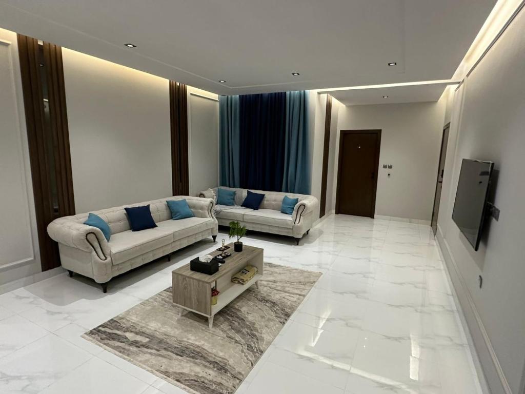 a living room with two couches and a tv at شقة مفروشة بمنطقة هادئة in Makkah