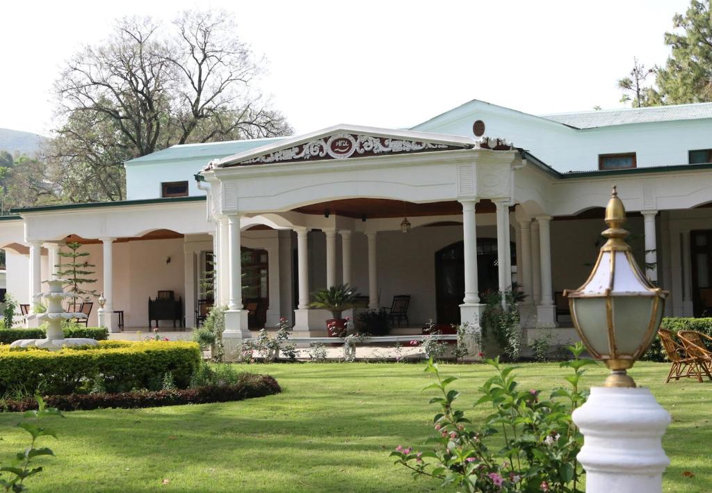 a white house with a pavilion in a yard at Swat Serena Hotel in Saidu