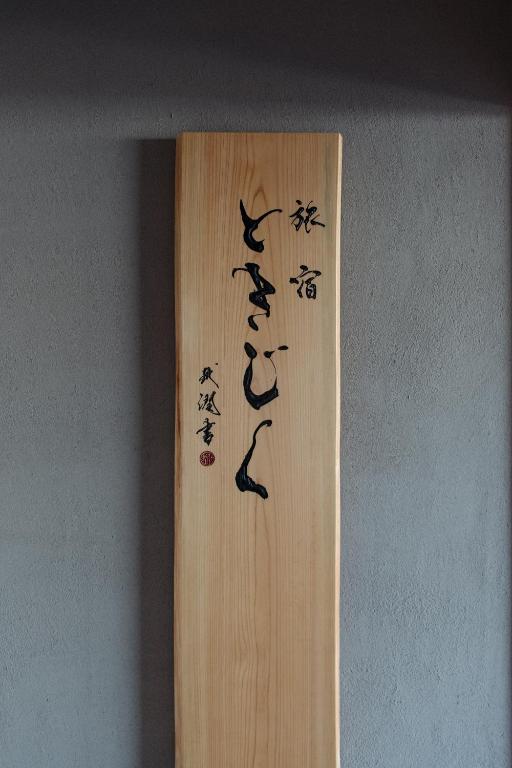 a wooden sign with asian writing on a wall at 旅宿ときじくTokijiku in Nachikatsuura