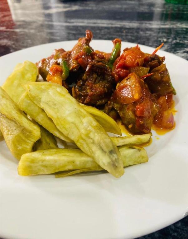 a plate of food with meat and vegetables and chips at Udokanson Hotel And Suites in Agbor