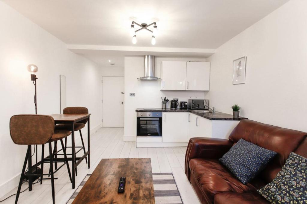 a living room with a couch and a table at Commercial Road Apartments Central Location Wyvern Theatre in Swindon