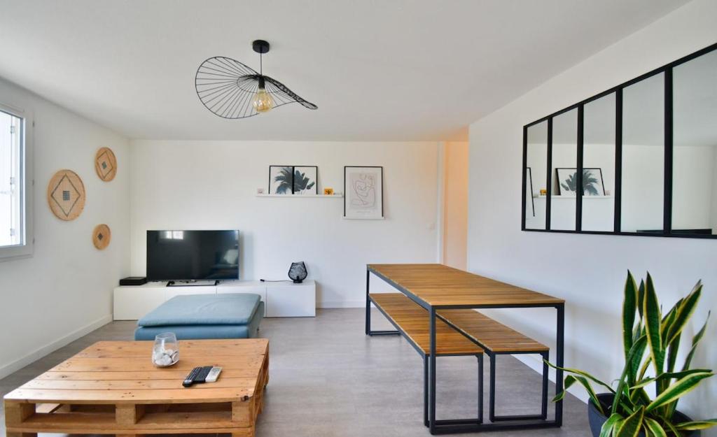 un salon avec une table et un canapé dans l'établissement Bruyères with deck and private parking, à Montpellier