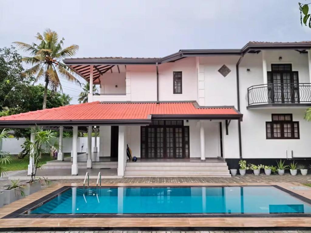 a house with a swimming pool in front of it at Tharan Villa - House in Colombo in Polgasowita