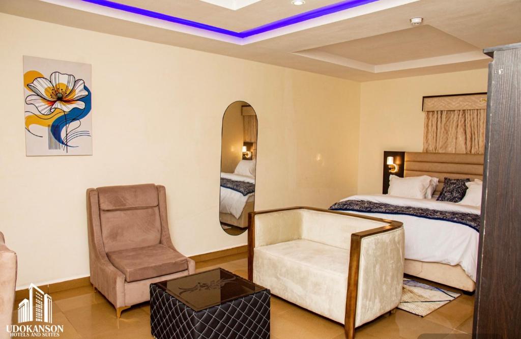a hotel room with a bed and a chair at Udokanson Hotel And Suites in Agbor