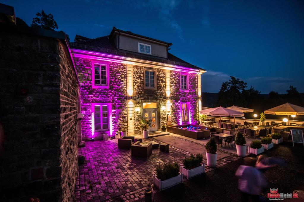 a building with purple lights on it at night at Berghotel Eisenach in Eisenach