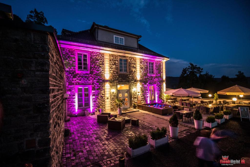 un edificio con luci viola sopra la notte di Berghotel Eisenach a Eisenach