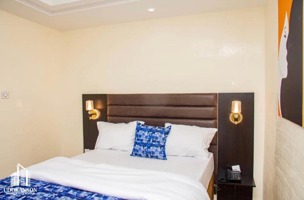a bedroom with a bed with a wooden headboard at Udokanson Hotel And Suites in Agbor