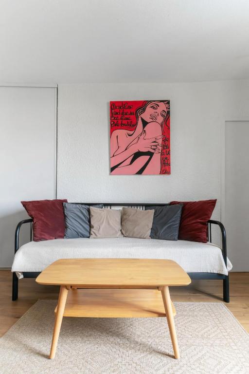 a living room with a bed and a wooden coffee table at Grande Maison Clermont - Appartements centre ville in Clermont-Ferrand