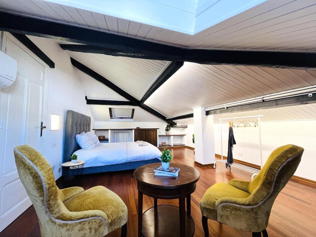 Hotel La casa di MEK, a bedroom with a bed and two chairs and a table at La casa di MEK in Sanremo