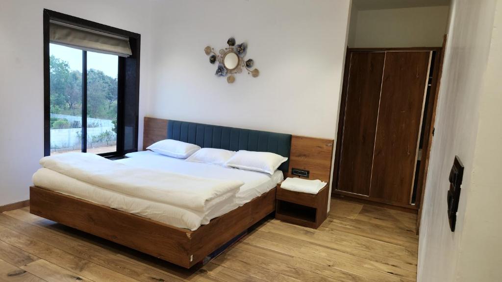 a bedroom with a bed and a large window at Farmstay Fusion in Shamshabad