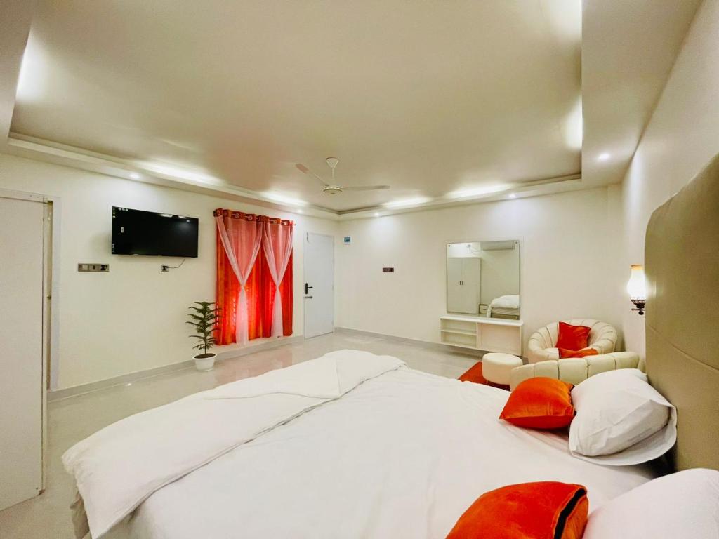 库克斯巴扎Sun Oasis Resort的一间白色的大卧室,配有一张大床和一台电视