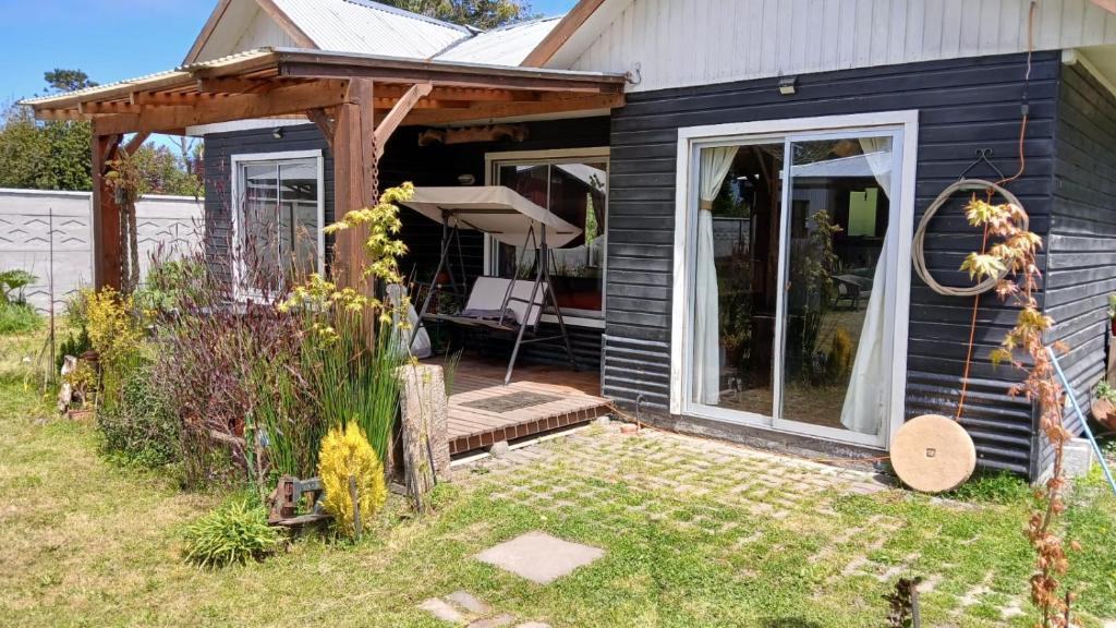 a house with a porch and a deck with a chair at Costa Monkul - Carahue y Puerto Saavedra in Nahuentúe