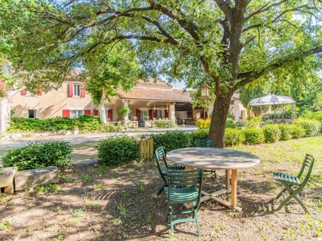 Gite - Domaine Les Peupliers - Lagnes في Lagnes: طاولة وكراسي تحت شجرة في ساحة
