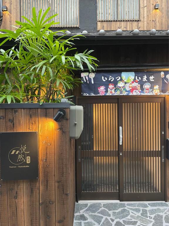 an entrance to a building with a gate and plants at 悦然民宿-天下茶屋 in Osaka