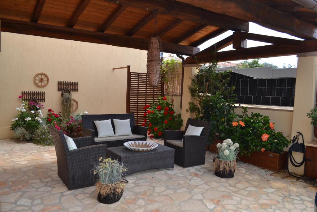 a patio with couches and chairs on a patio at Sweet House in Villasimius