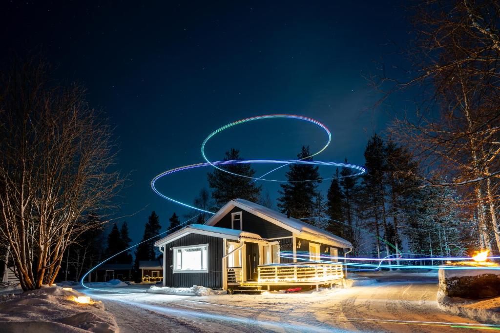 Una casa en la nieve por la noche con un círculo en el cielo en Charming house near the city, en Rovaniemi