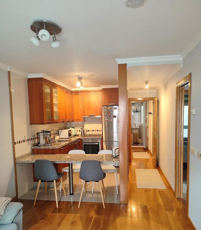 a kitchen with a counter and some chairs in it at Piso centro A Coruña in A Coruña