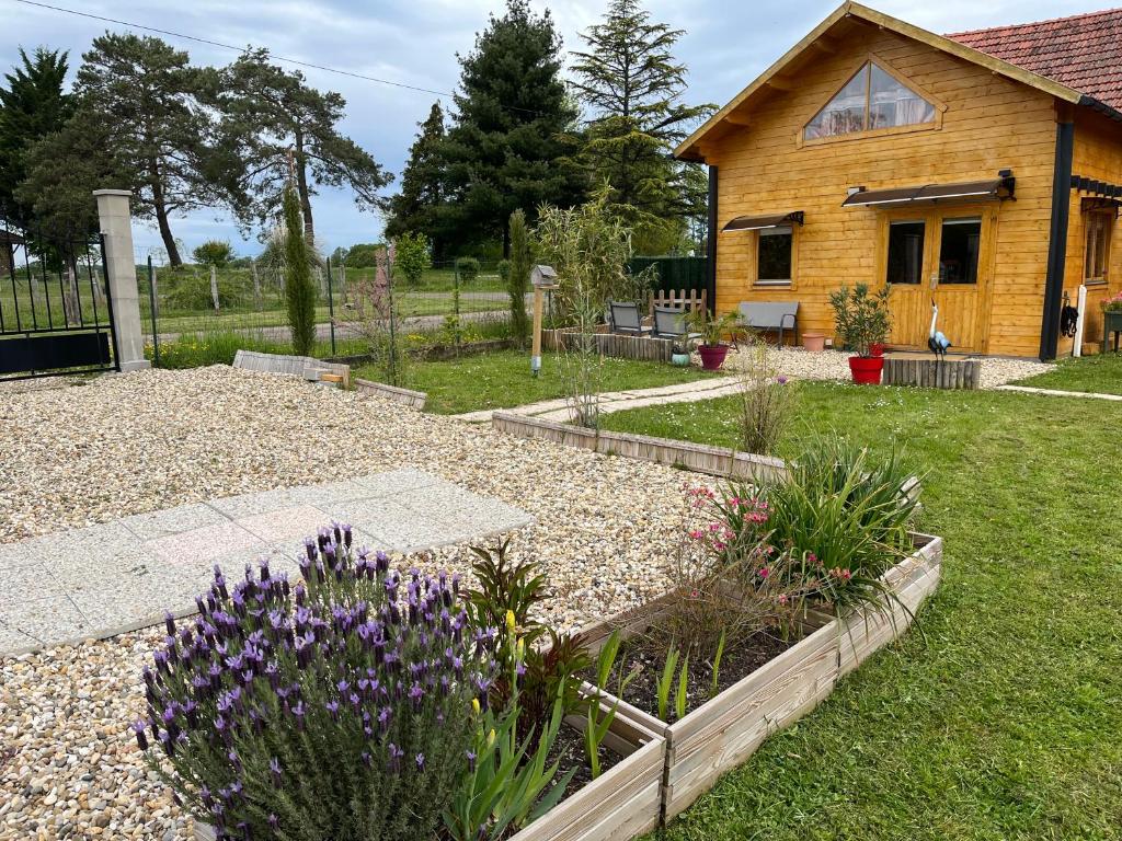 un jardin avec des fleurs violettes devant une maison dans l'établissement Le rouge gorge, à Bosjean