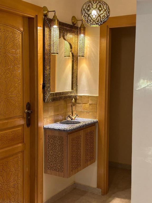 ein Badezimmer mit Waschbecken und Spiegel in der Unterkunft Fez Spacious Stay with Moroccan Artisanal Charm in Fès