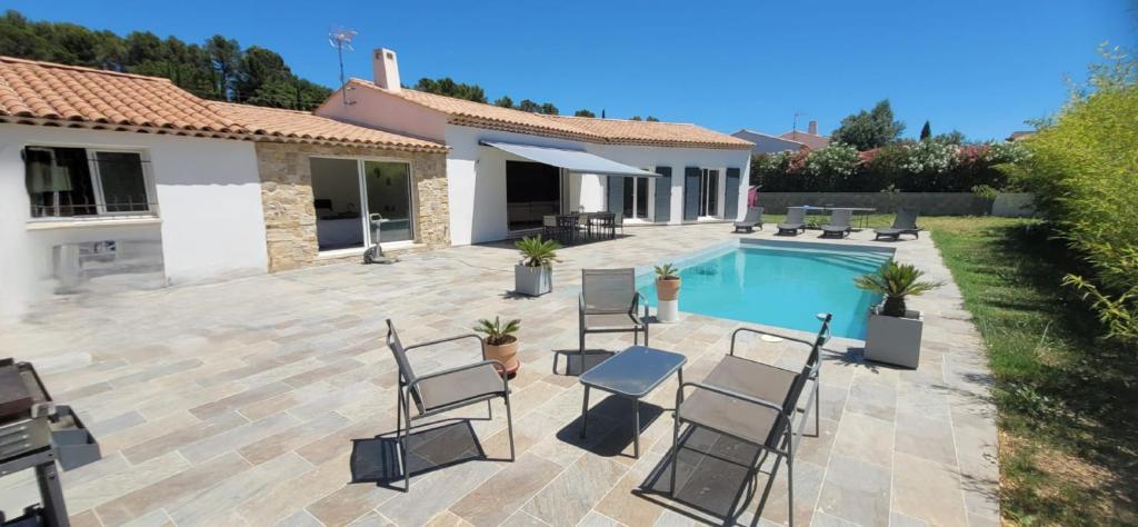 un patio avec des chaises et une piscine dans l'établissement villa, à Lorgues