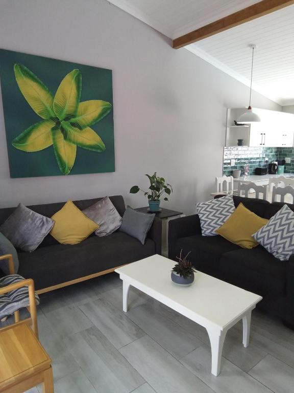 a living room with two couches and a table at Marina Cottage in Marina Da Gama