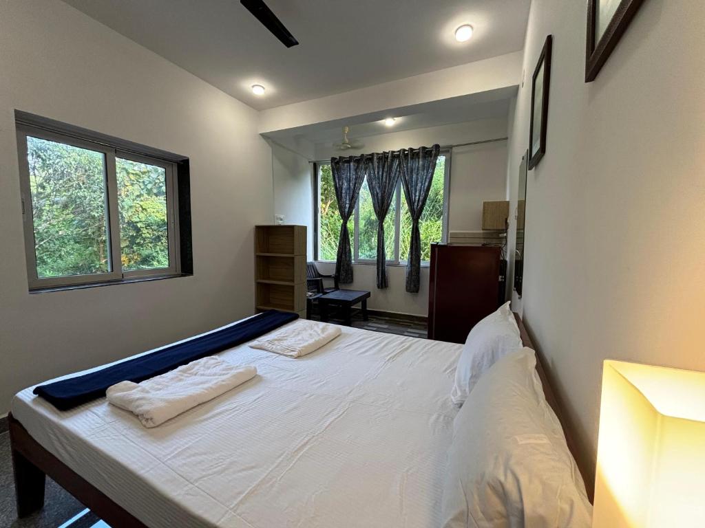a bedroom with a bed with two towels on it at Studio Green Haven- R 7 by Mukund Sadan Arambol in Arambol