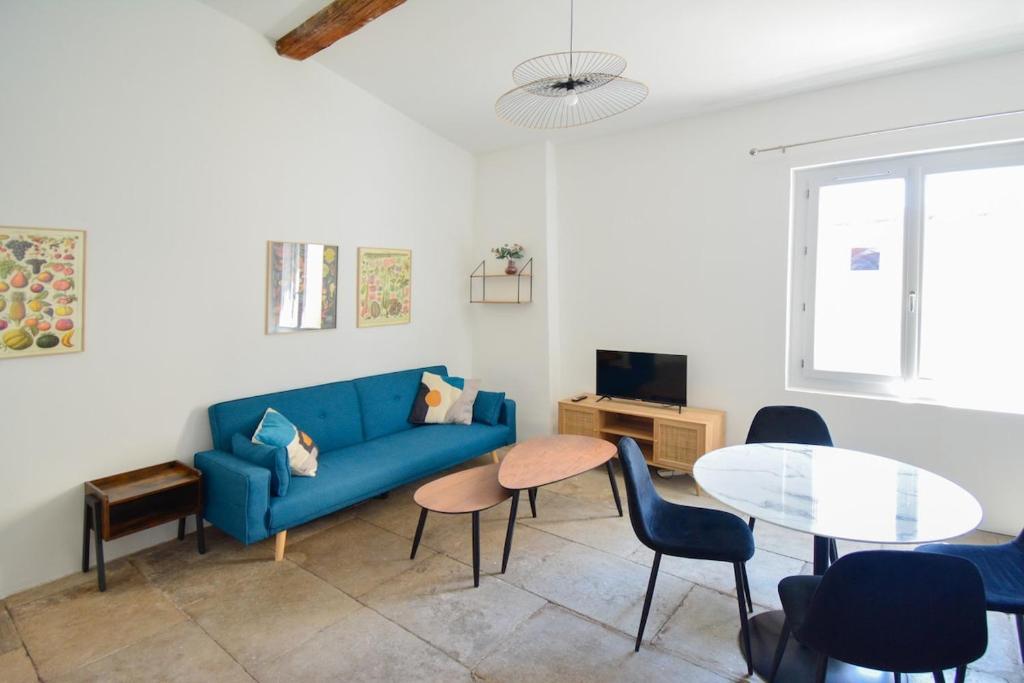 a living room with a blue couch and a table at Ecusson - Centre Historique in Montpellier
