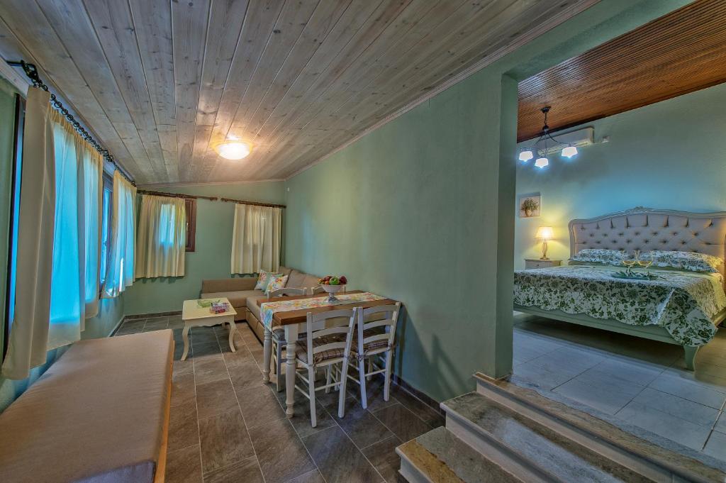 a room with a bed and a table and chairs at Pounda Paou in Metókhion