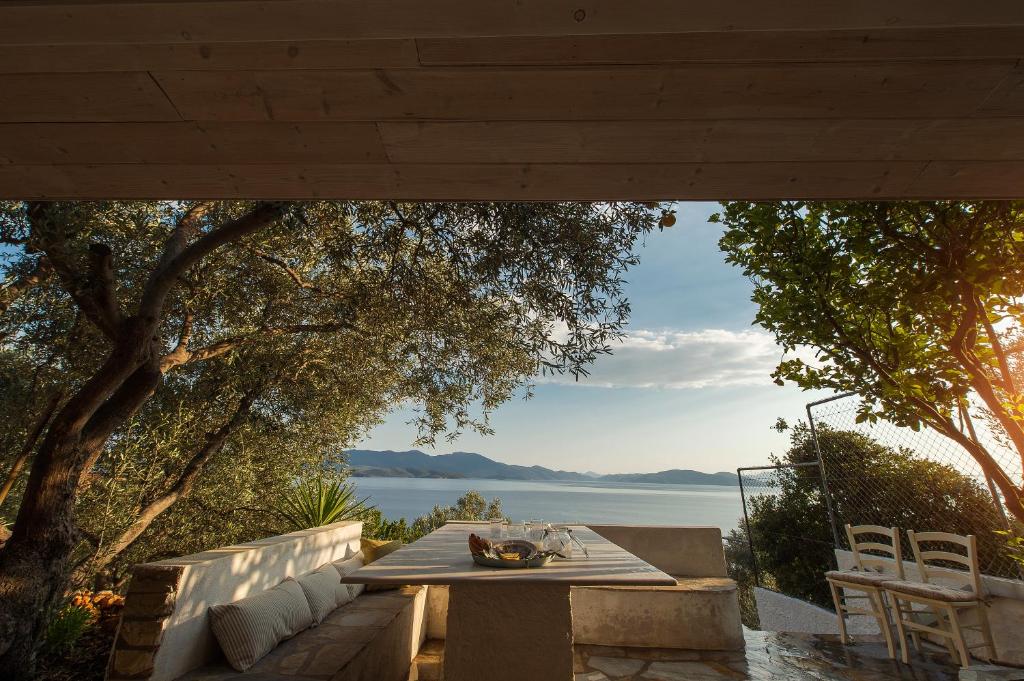 a table and chairs on a patio with a view of the water at Pounda Paou in Metókhion