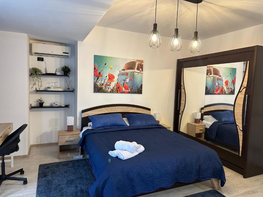a bedroom with a blue bed and a mirror at Central Studio Bucur in Bucharest