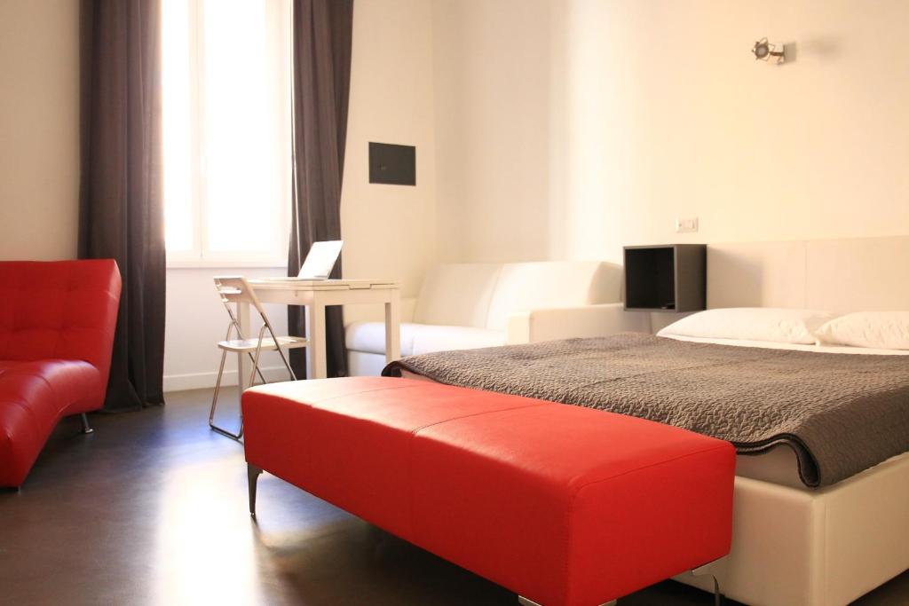 ローマにあるI LOVE ROMA Guest Houseのベッドと赤いベンチ付きのホテルルーム